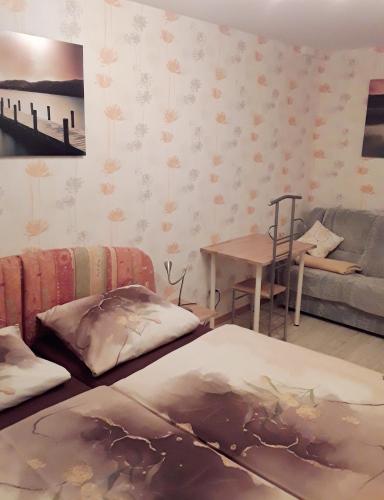 a room with two beds and a couch and a table at Ferienhaus Pieper in Thale