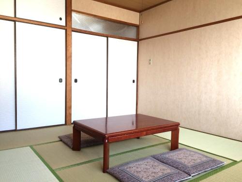 a room with a bench in front of some windows at Shodoshima Olive Youth Hostel in Shodoshima