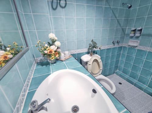 bagno blu con vasca e servizi igienici di The Chanthong Residence and Hotel Pattaya a Pattaya Sud