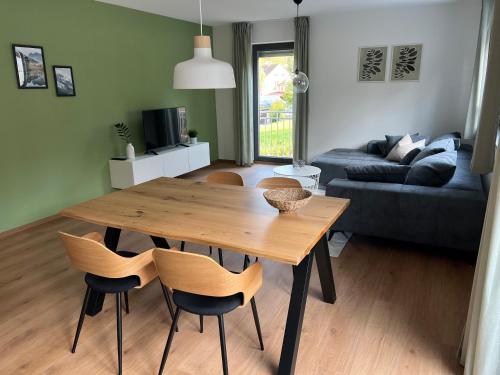 - un salon avec une table et des chaises en bois dans l'établissement Ferienwohnungen am Jura, à Weißenburg in Bayern