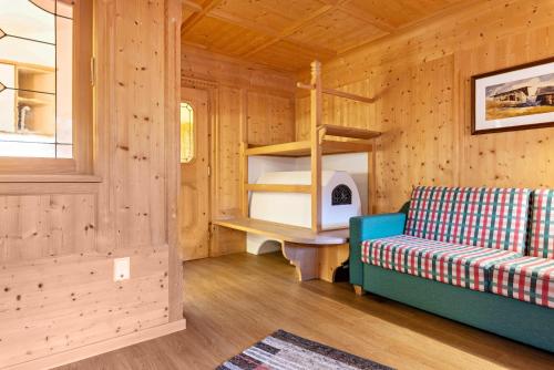 a room with a couch and a shelf in a cabin at Cesa Valeria App Monika in Ortisei