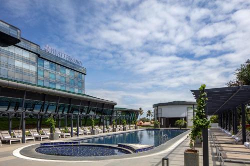 a hotel with a swimming pool in front of a building at Hyatt Regency Trivandrum in Trivandrum