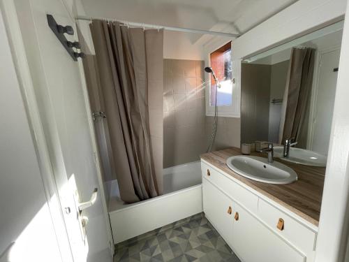 uma casa de banho com um lavatório e um espelho em Bel appartement rénové, central et skis aux pieds em Morzine