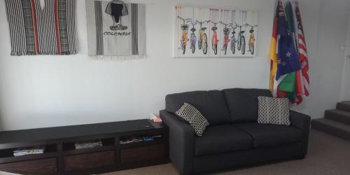 a living room with a black couch and a flag at Modest comfortable relaxed home away from home in Rotorua