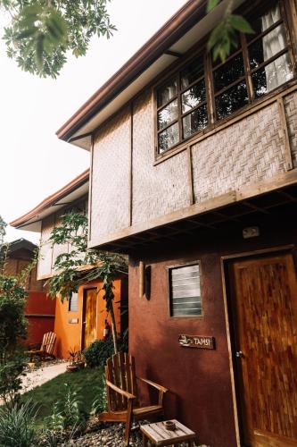 a house with a wooden door and a chair at Nakabalo Guesthouse & Restaurant in Siquijor