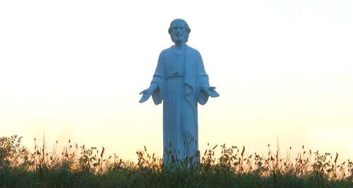 a statue of a man standing in a field at Bio Archehof Zachhiesen - stay & relax in Seekirchen am Wallersee