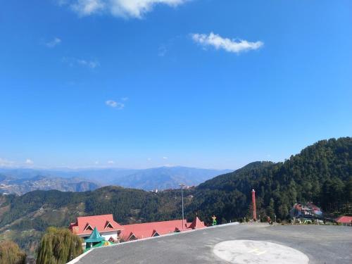 a view of a road with a mountain in the background at Hotel The Twin Towers in Shimla