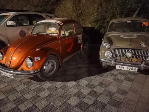 two old cars parked next to each other on a street at Hotel The Twin Towers in Shimla