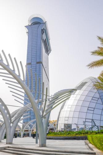 a tall building with a palm tree in front of it at Ultra Luxury Palm Tower with Shared Hotel Facilities in Dubai