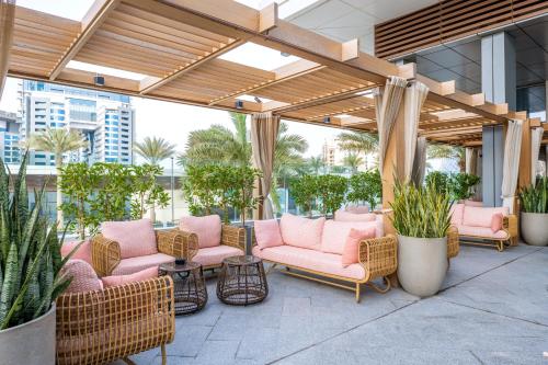 a patio with pink chairs and plants in a building at Ultra Luxury Palm Tower with Shared 5 Star Hotel Facilities in Dubai