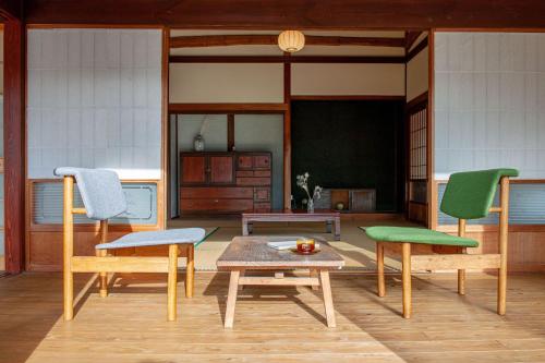 a living room with two chairs and a table at entohouse BAR&GUESTHOUSE 