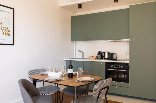 a dining room with a table and chairs and a kitchen at Appartement Dify Deruelle - Part Dieu in Lyon