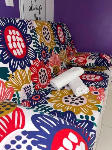 um sofá com um cobertor florido em cima em Studio cosy, 1-2 pers em Noiseau