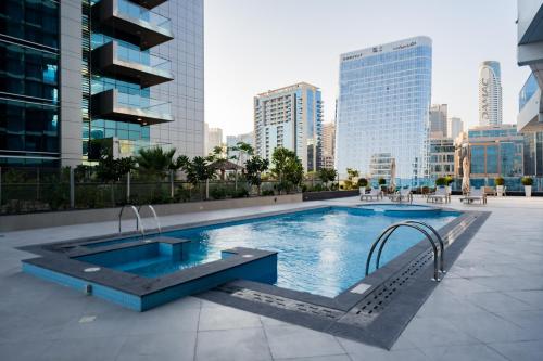 ein Schwimmbad mitten in einer Stadt in der Unterkunft Kasco Homes Waves Tower Business Bay in Dubai