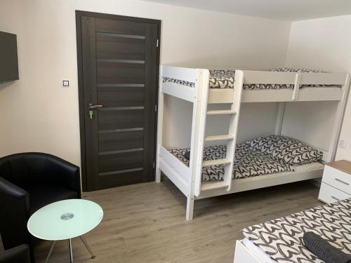 a room with two bunk beds and a table at Apartmán u Drahotů in Pernink