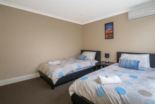 two beds in a room with two beds sidx sidx sidx sidx at Ocean View Executive Apartment 2 in Busselton