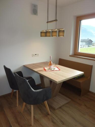 a dining room table with two chairs and a window at Apart MARI in Fügen