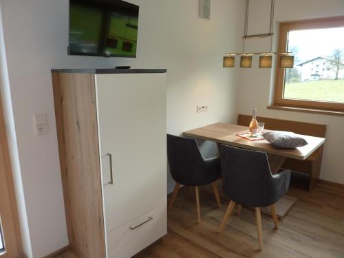 a small kitchen with a table and a refrigerator at Apart MARI in Fügen