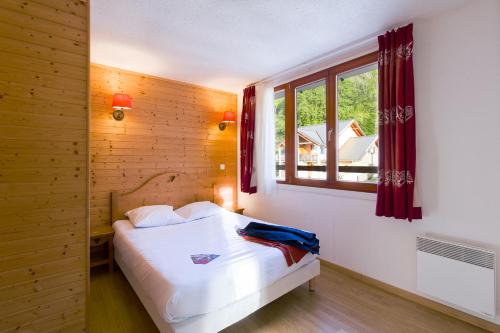 een slaapkamer met een wit bed en een raam bij Garden & City Evian - Lugrin in Lugrin