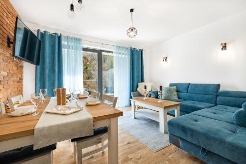 a living room with a blue couch and a table at Apartament Ale Widok in Szczyrk