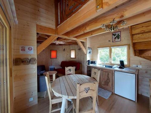 eine Küche und ein Esszimmer mit einem Tisch in einer Hütte in der Unterkunft Roulottes au pied du Vercors in Saint-Jean-en-Royans