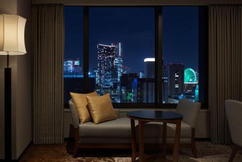 Zimmer mit einem Fenster, einem Sofa und einem Tisch in der Unterkunft Hyatt Regency Yokohama in Yokohama