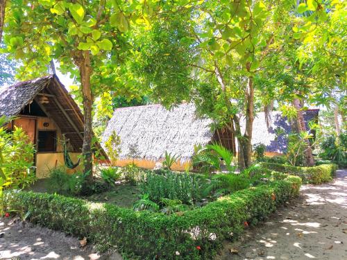 a garden in front of a house with trees at Sulu Sunset Beach Resort in Nauhang