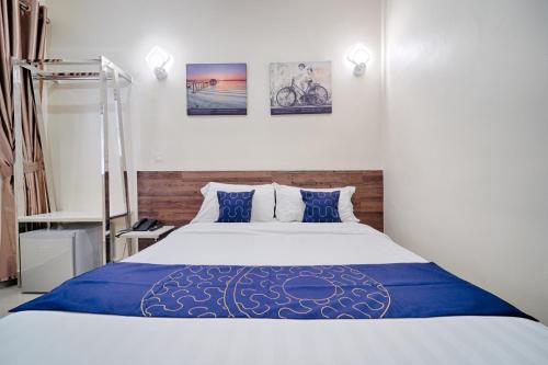 a bedroom with a bed with blue and white sheets at Avatel Jelutong in George Town