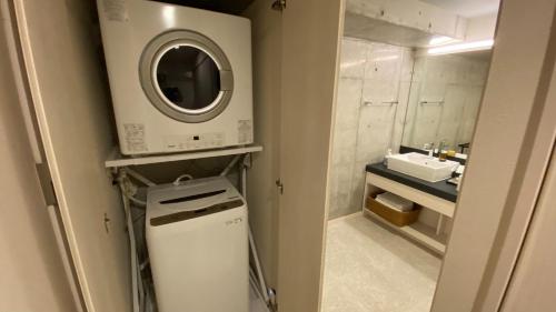 a laundry room with a washing machine and a sink at Tabinoteitaku Okinawa Naha 2nd in Naha