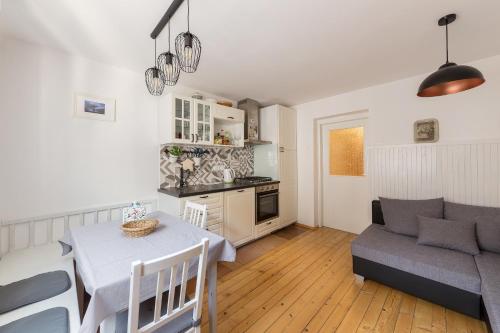 a kitchen and living room with a table and a couch at Apartma Ivana & Ivanka in Bohinj