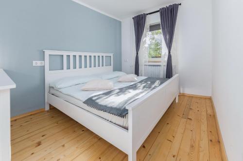 a white bed in a room with a window at Apartma Ivana & Ivanka in Bohinj