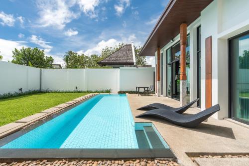 a swimming pool in the backyard of a house at Beautiful 3 bedroom pool villa with 65inch smart tv Located near popular Bangtao beach and laguna Phuket in Bang Tao Beach