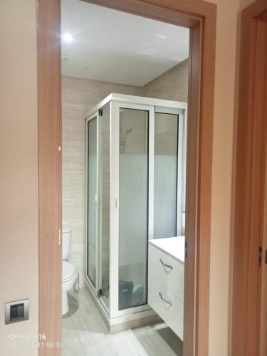uma casa de banho com uma cabina de duche em vidro e um WC. em Appartement Prestigia Golf Marrakech em Marrakech