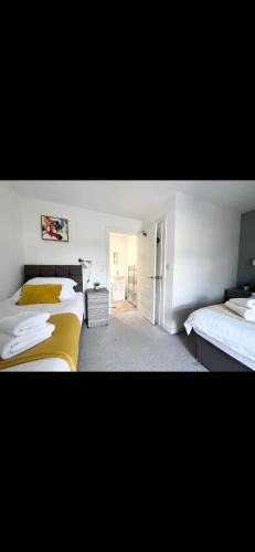 1 dormitorio con 2 camas con sábanas amarillas en Homely and Deceptively large city house, en Swansea