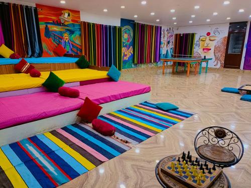 a colorful living room with two beds and a table at Gypsy Diaries Varanasi in Varanasi