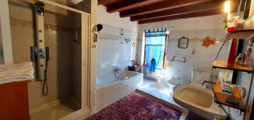 ein Bad mit einer Badewanne, einem Waschbecken und einer Dusche in der Unterkunft Gardasee -RESIDENZA POETICA-Garda lake in Cavaion Veronese