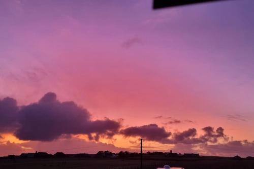 a sunset with a pink and purple sky at The back pod in Vatsker