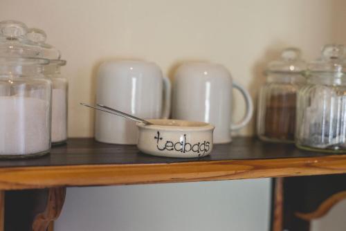 a shelf with jars and a cup on it at Thokozani Lodge in White River