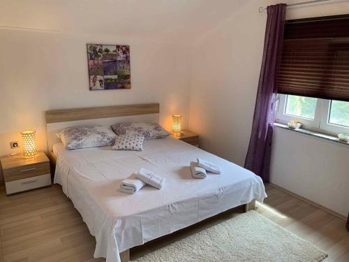 a bedroom with a white bed with towels on it at Apartment in Bribir 15452 in Bribir