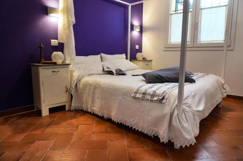 a bedroom with a white bed with a purple wall at Corte Cantoni in Nonantola