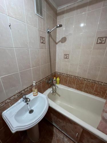 a bathroom with a sink and a bath tub at Стандарт Камзина 74 г. Павлодар in Pavlodar