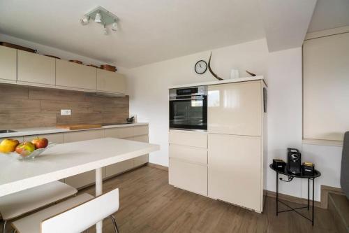 a kitchen with white cabinets and a bowl of fruit on a counter at Ales Green in Camorino