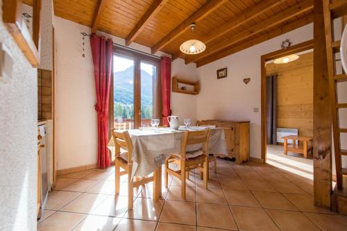 a kitchen and dining room with a table and chairs at Fleurs et Neige in Lanslevillard