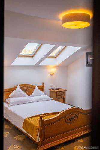 a bedroom with a bed with skylights in the ceiling at Hotel Aldi in Gura Humorului