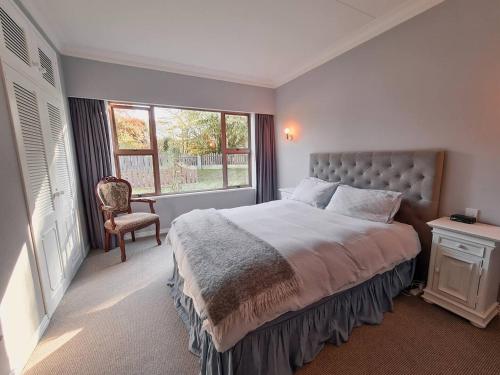 - une chambre avec un lit, une fenêtre et une chaise dans l'établissement Wonderful Woodlands Estate, 