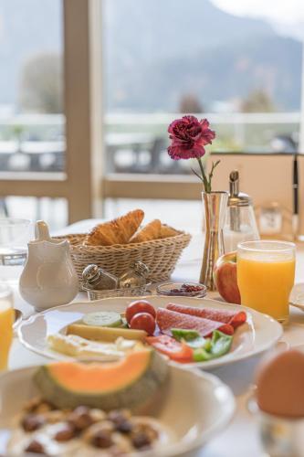 een tafel met borden en een mand brood bij Schüle's Wellnessresort & SPA Adults Only in Oberstdorf