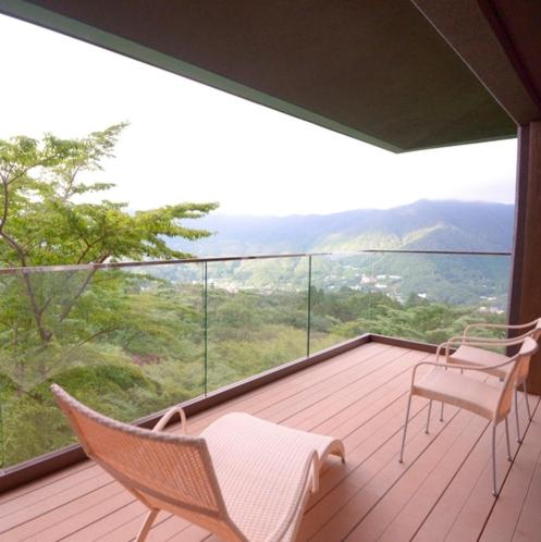a balcony with two chairs and a large window at Hakone Gora Byakudan in Hakone