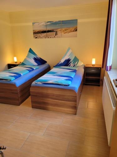 2 Betten in einem Zimmer mit blauen Kissen in der Unterkunft Ferienwohnung mit 2 Schlafzimmern in Zinnowitz