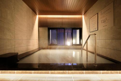 a room with a bath tub with a window at Via Inn Prime Akasaka in Tokyo