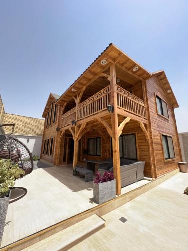 a large wooden house with a large deck at أكواخ غيم ومطر in Al Hada